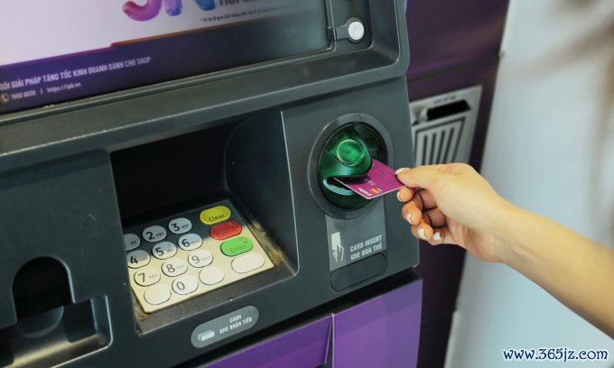 Một người đang giao dịch tại cây ATM. Ảnh: Ngọc Thành